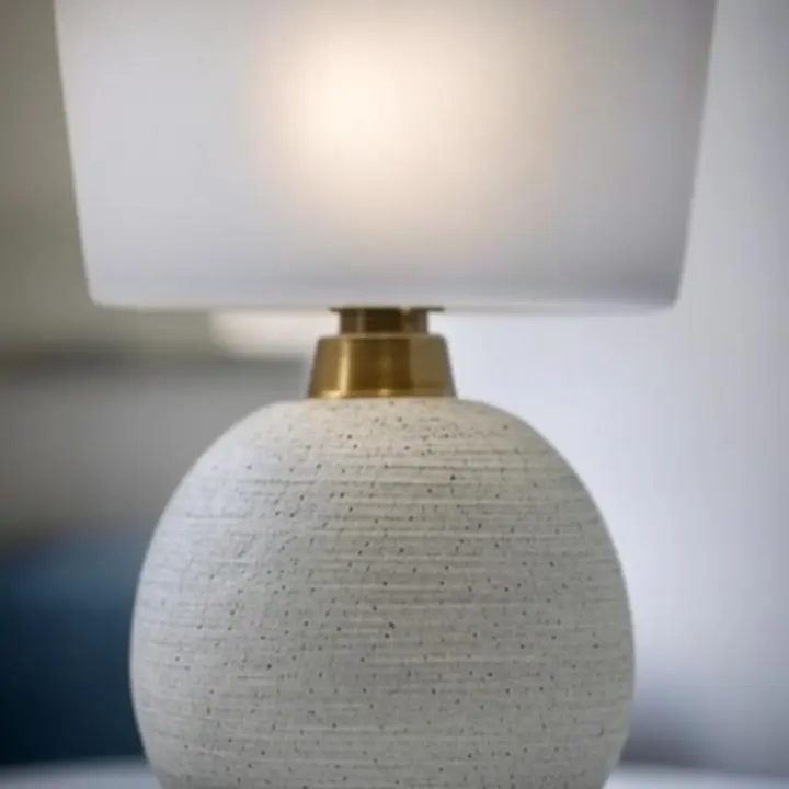 Zbliżenie na teksturowany klosz dekoracyjnej lampy z eleganckim złotym wykończeniem